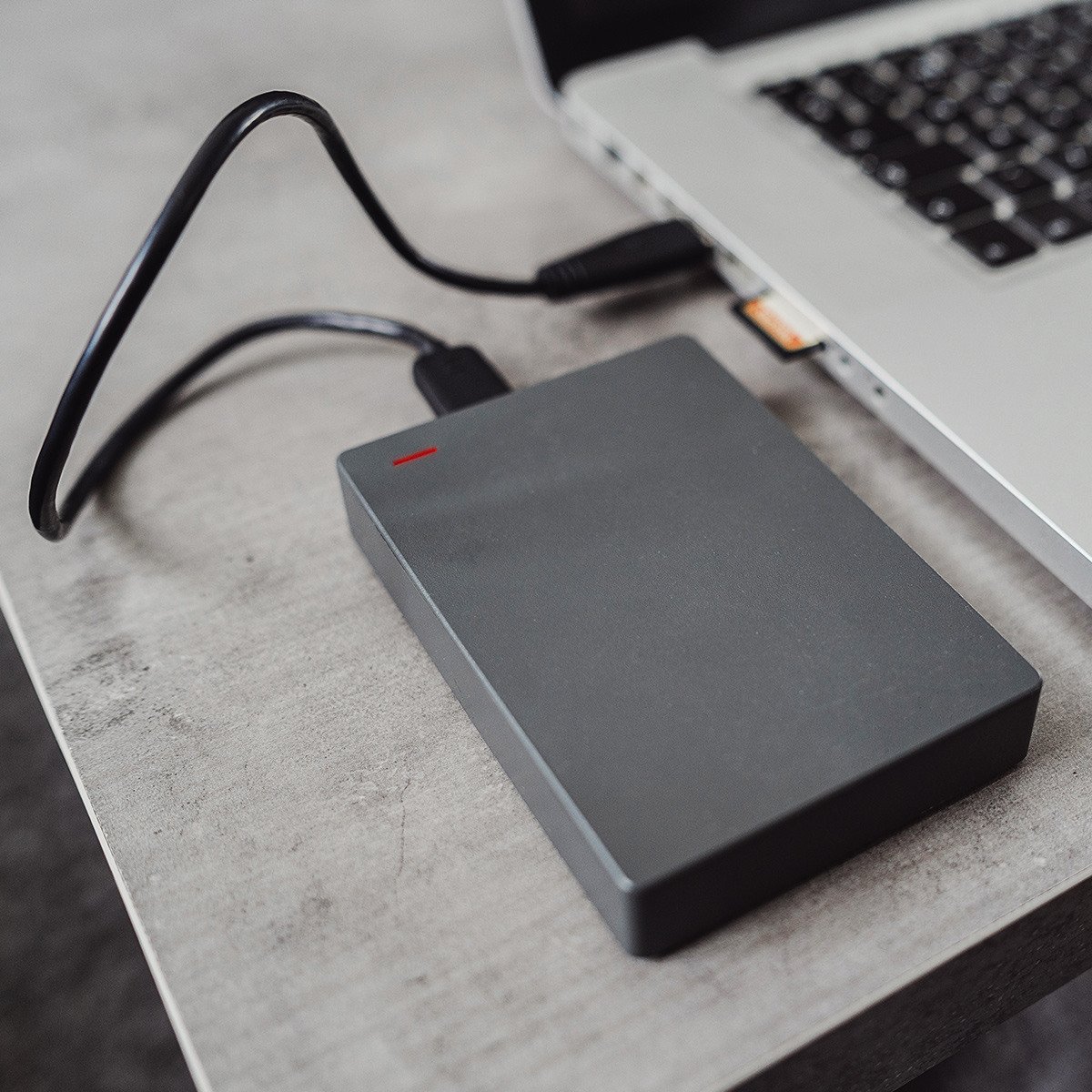Hard drive next to a laptop